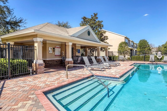 rear view of property with fence, a patio area, and a community pool