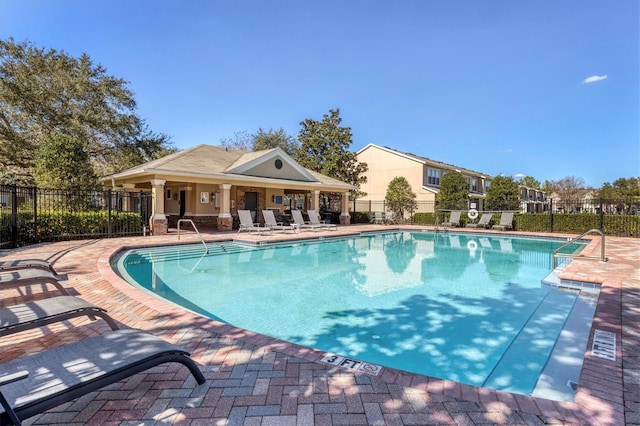 community pool with fence and a patio area