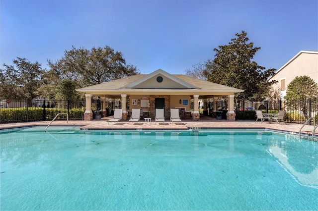 community pool featuring fence and a patio