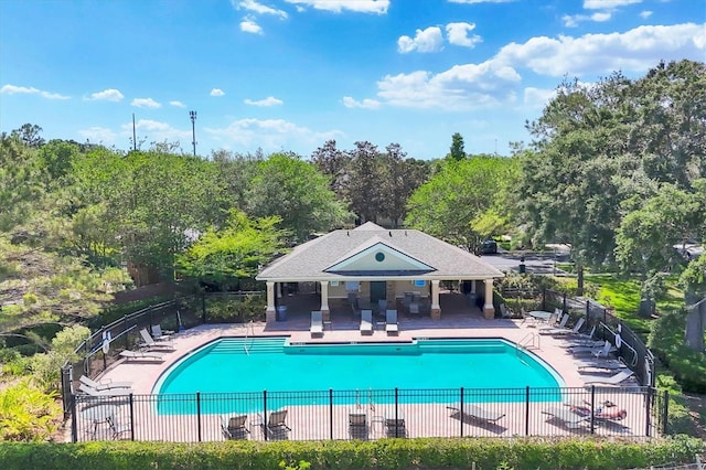 community pool with fence and a patio area
