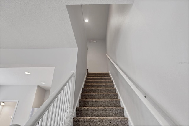 stairway with recessed lighting and carpet floors