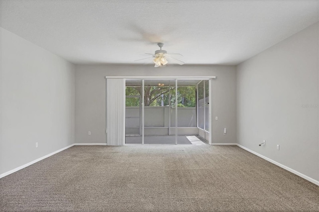 carpeted spare room with a ceiling fan and baseboards