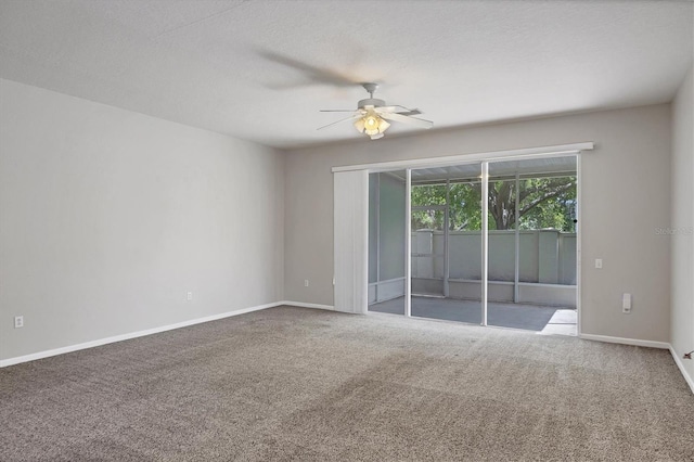 carpeted empty room featuring ceiling fan and baseboards