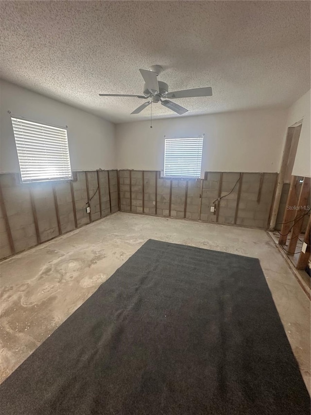 unfurnished room featuring a textured ceiling and a ceiling fan