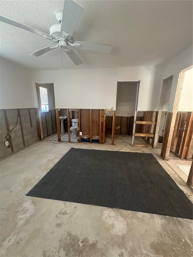 misc room featuring concrete floors, a textured ceiling, and ceiling fan