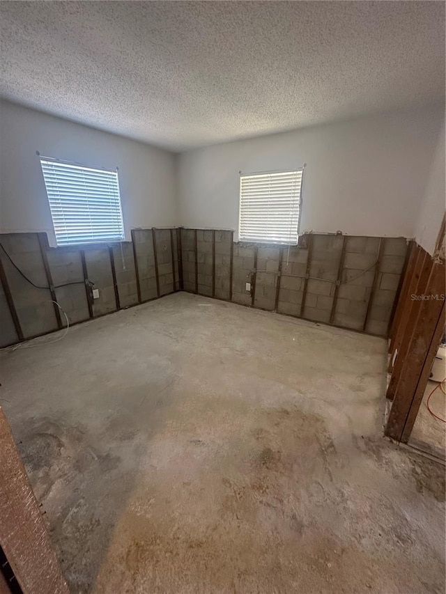 empty room with concrete floors and a textured ceiling
