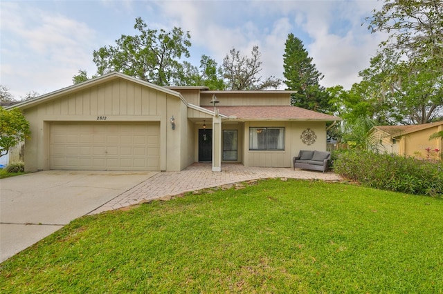 single story home featuring driveway, an attached garage, and a front yard