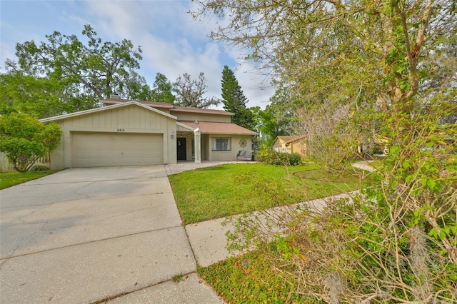 ranch-style home featuring driveway, a front yard, and a garage