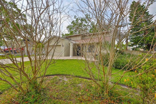 view of yard featuring a patio, a garage, and fence