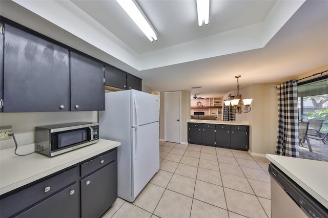 kitchen with light countertops, stainless steel appliances, an inviting chandelier, and light tile patterned floors