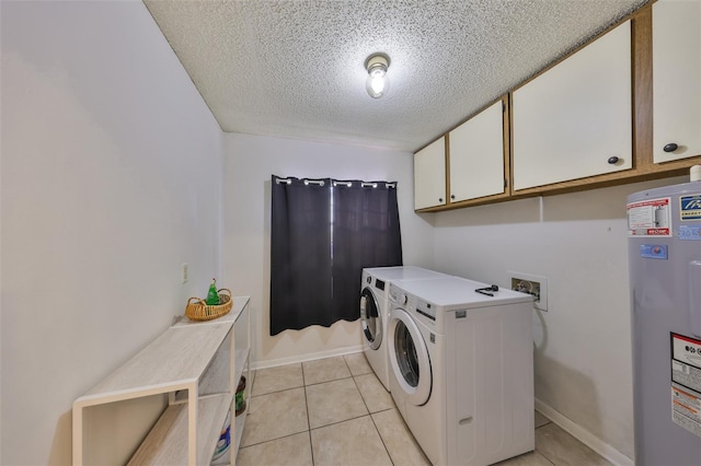 washroom featuring electric water heater, light tile patterned floors, separate washer and dryer, a textured ceiling, and cabinet space