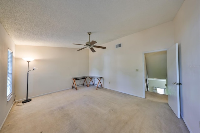 empty room featuring a ceiling fan, carpet floors, a textured ceiling, and visible vents