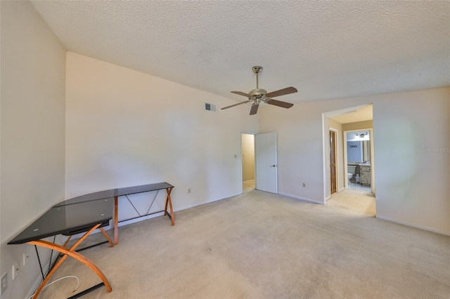 carpeted empty room featuring baseboards, a textured ceiling, ceiling fan, and visible vents