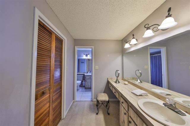 bathroom with vanity, baseboards, and a textured ceiling