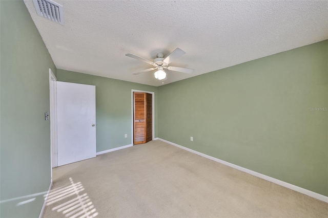 unfurnished bedroom with a closet, carpet flooring, a textured ceiling, baseboards, and visible vents