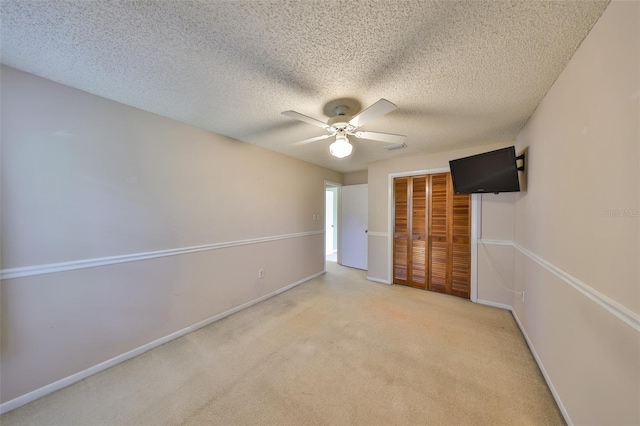 unfurnished bedroom with light carpet, baseboards, a closet, and a textured ceiling
