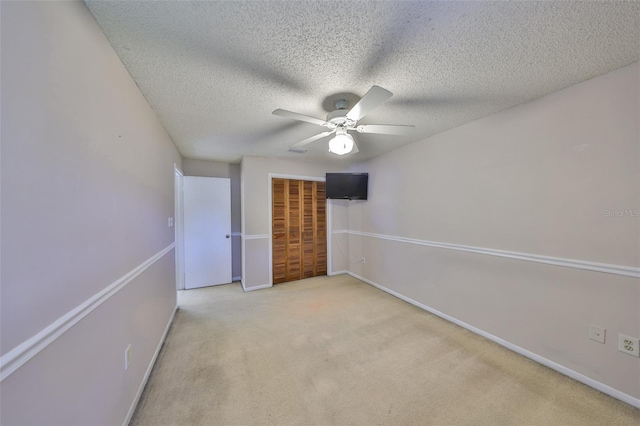 unfurnished bedroom with carpet flooring, baseboards, a closet, and a textured ceiling
