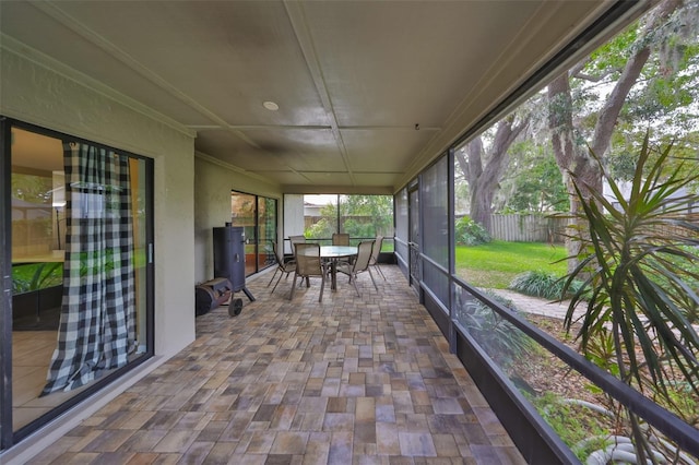 sunroom / solarium with ornamental molding and outdoor dining space