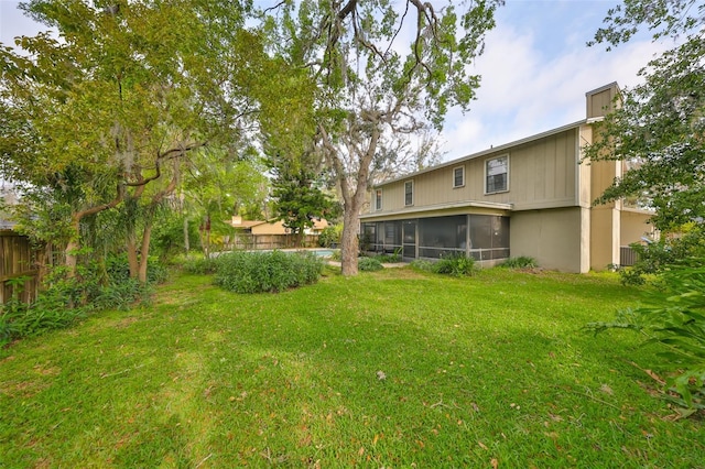 view of yard featuring a sunroom and fence