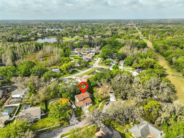 drone / aerial view with a water view and a forest view