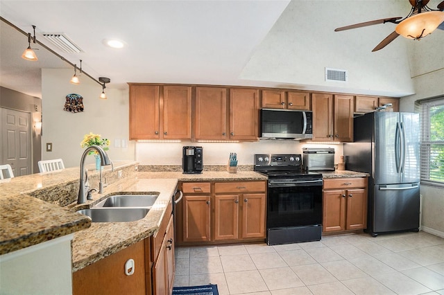 kitchen featuring brown cabinetry, appliances with stainless steel finishes, a sink, and visible vents
