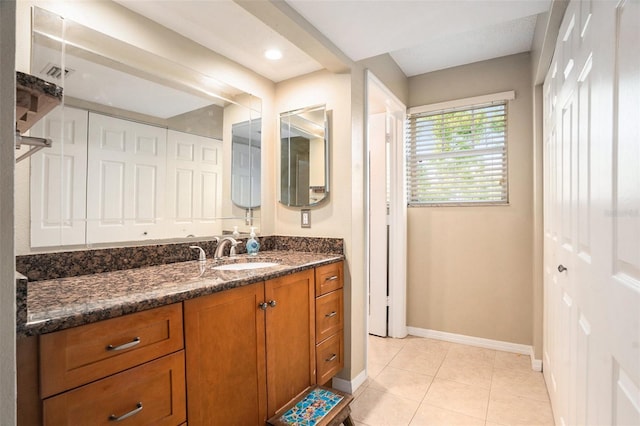 bathroom featuring tile patterned flooring, baseboards, and vanity