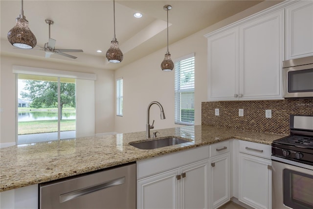19123 Sunset Bay Dr, Land O Lakes, FL 34638 - kitchen with white cabinets, a sink, stainless steel appliances, a ceiling fan, and tasteful backsplash