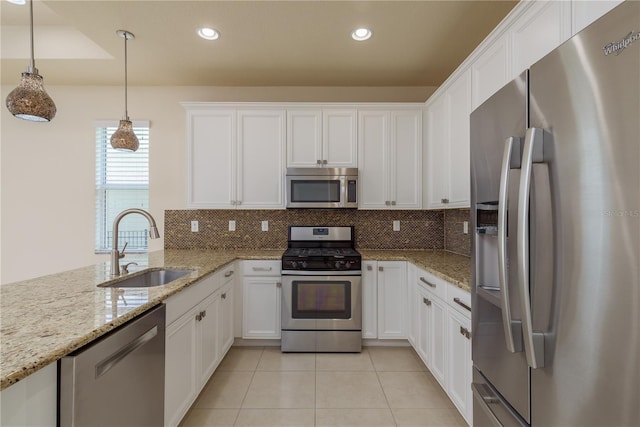 19123 Sunset Bay Dr, Land O Lakes, FL 34638 - kitchen featuring a sink, stainless steel appliances, white cabinetry, decorative backsplash, and light tile patterned floors