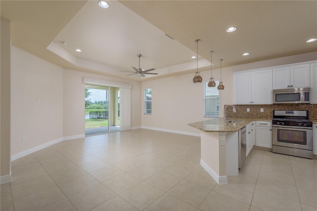 19123 Sunset Bay Dr, Land O Lakes, FL 34638 - kitchen featuring backsplash, appliances with stainless steel finishes, white cabinets, a peninsula, and recessed lighting