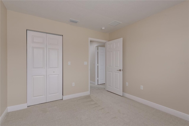 19123 Sunset Bay Dr, Land O Lakes, FL 34638 - unfurnished bedroom with a closet, baseboards, light colored carpet, and visible vents