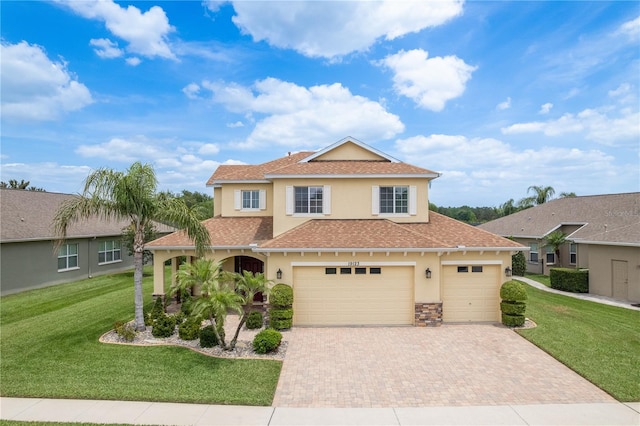 19123 Sunset Bay Dr, Land O Lakes, FL 34638 - mediterranean / spanish home with a garage, decorative driveway, a front lawn, a shingled roof, and stucco siding