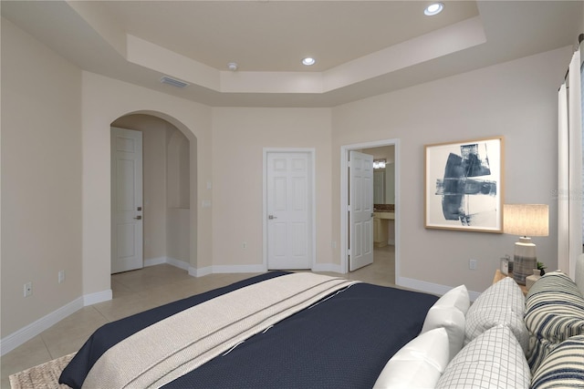 19123 Sunset Bay Dr, Land O Lakes, FL 34638 - bedroom with visible vents, light tile patterned flooring, recessed lighting, a raised ceiling, and arched walkways