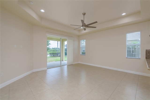 19123 Sunset Bay Dr, Land O Lakes, FL 34638 - unfurnished room with baseboards, a raised ceiling, ceiling fan, and a healthy amount of sunlight