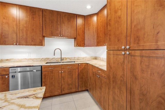 kitchen with a sink, light tile patterned flooring, dishwasher, light stone countertops, and brown cabinetry