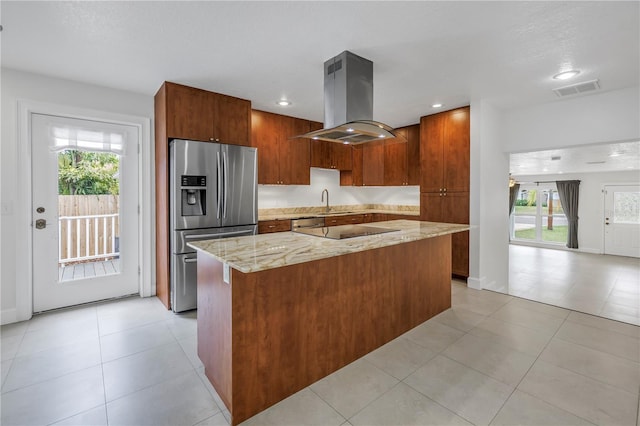 kitchen featuring stainless steel refrigerator with ice dispenser, a center island, island exhaust hood, black electric stovetop, and visible vents