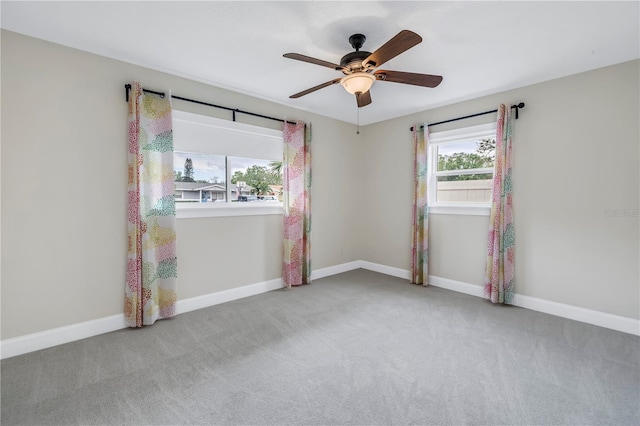 carpeted empty room with baseboards and a ceiling fan