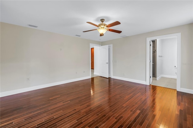 unfurnished room with baseboards, visible vents, wood finished floors, and ceiling fan