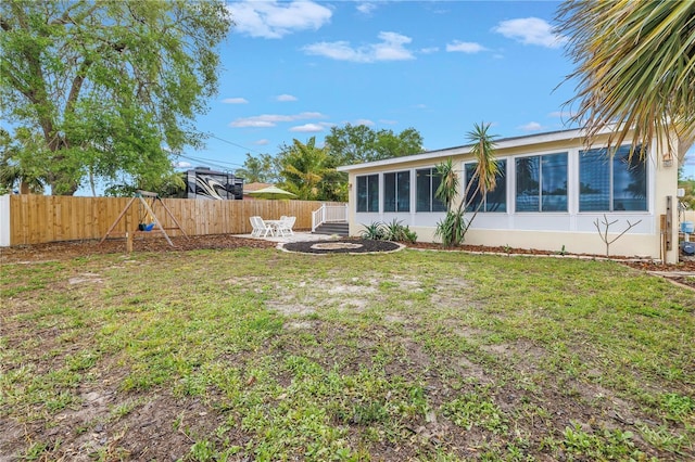 view of yard featuring a fenced backyard, a sunroom, and a patio area
