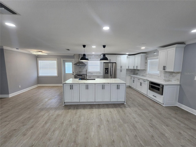 4619 Helena St NE, Saint Petersburg, FL 33703 - kitchen with decorative backsplash, visible vents, stainless steel appliances, light wood-style floors, and wall chimney range hood