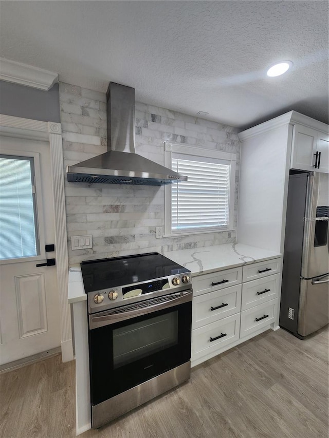 4619 Helena St NE, Saint Petersburg, FL 33703 - kitchen with a healthy amount of sunlight, light wood-style flooring, stainless steel appliances, and wall chimney exhaust hood