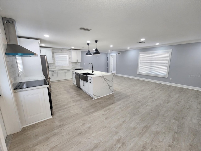4619 Helena St NE, Saint Petersburg, FL 33703 - kitchen featuring backsplash, a sink, light wood finished floors, white cabinetry, and wall chimney range hood