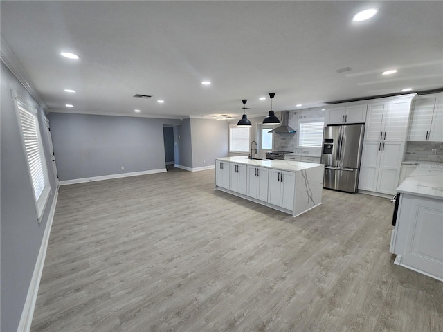 4619 Helena St NE, Saint Petersburg, FL 33703 - kitchen featuring decorative backsplash, wall chimney exhaust hood, light wood-style flooring, and stainless steel refrigerator with ice dispenser