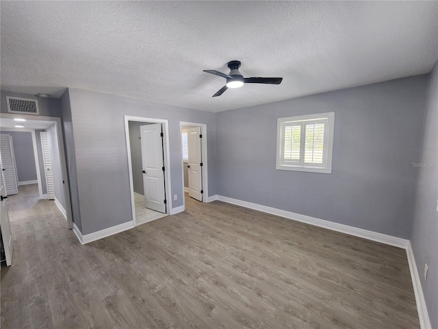 4619 Helena St NE, Saint Petersburg, FL 33703 - unfurnished bedroom with baseboards, a textured ceiling, and wood finished floors