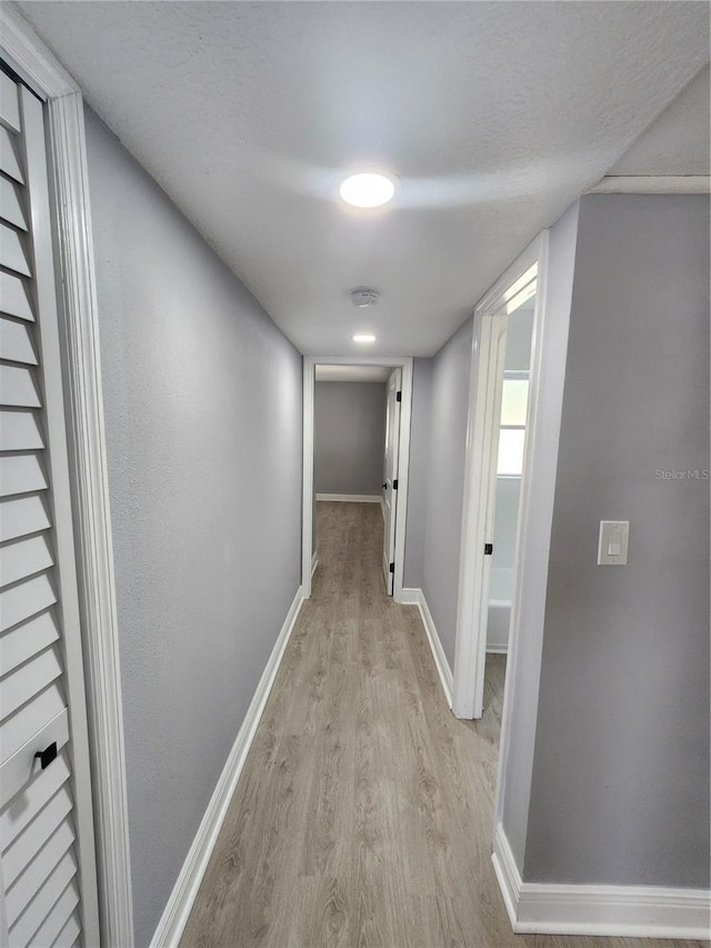 4619 Helena St NE, Saint Petersburg, FL 33703 - hall featuring baseboards, light wood-style flooring, and a textured ceiling