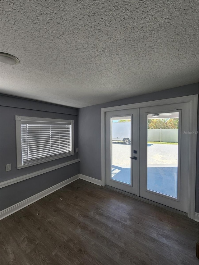 4619 Helena St NE, Saint Petersburg, FL 33703 - spare room featuring french doors, a textured ceiling, baseboards, and dark wood finished floors