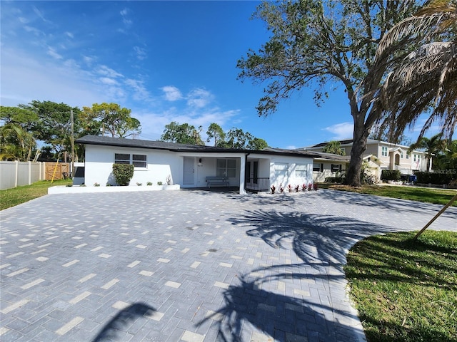 4619 Helena St NE, Saint Petersburg, FL 33703 - ranch-style house with driveway, stucco siding, fence, and a garage