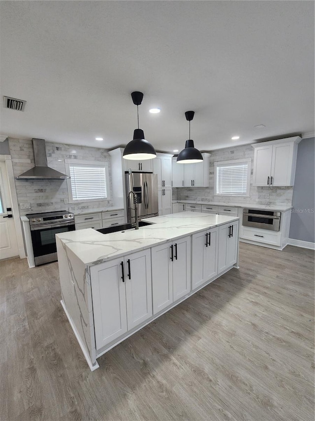 4619 Helena St NE, Saint Petersburg, FL 33703 - kitchen with decorative backsplash, visible vents, wall chimney range hood, and stainless steel appliances