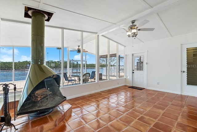 unfurnished sunroom featuring beamed ceiling and a healthy amount of sunlight
