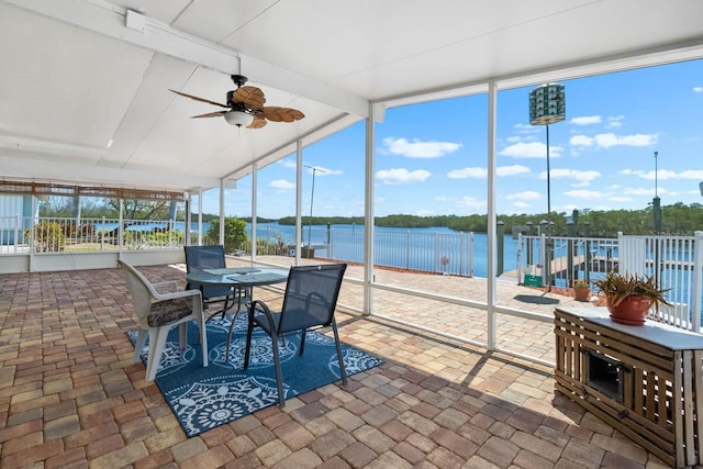 sunroom / solarium featuring a water view, a wall of windows, a ceiling fan, and outdoor dining area