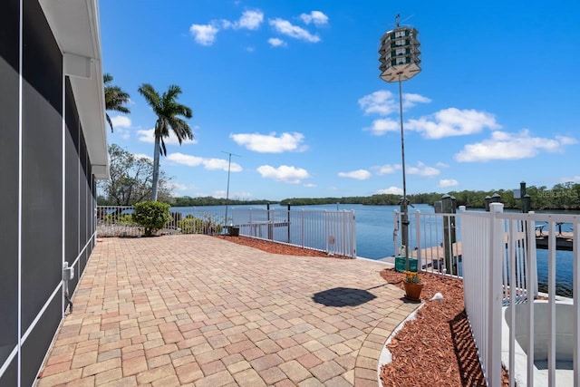 view of patio / terrace with a water view and glass enclosure